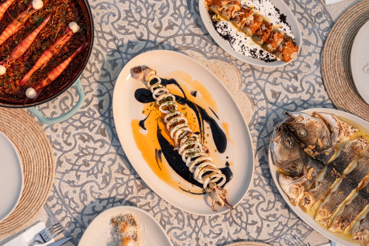 Rice with carabinero prawns, squid, roasted leeks and catch of the day on a table at The Sea Club